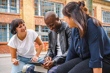 Three students with a tablet